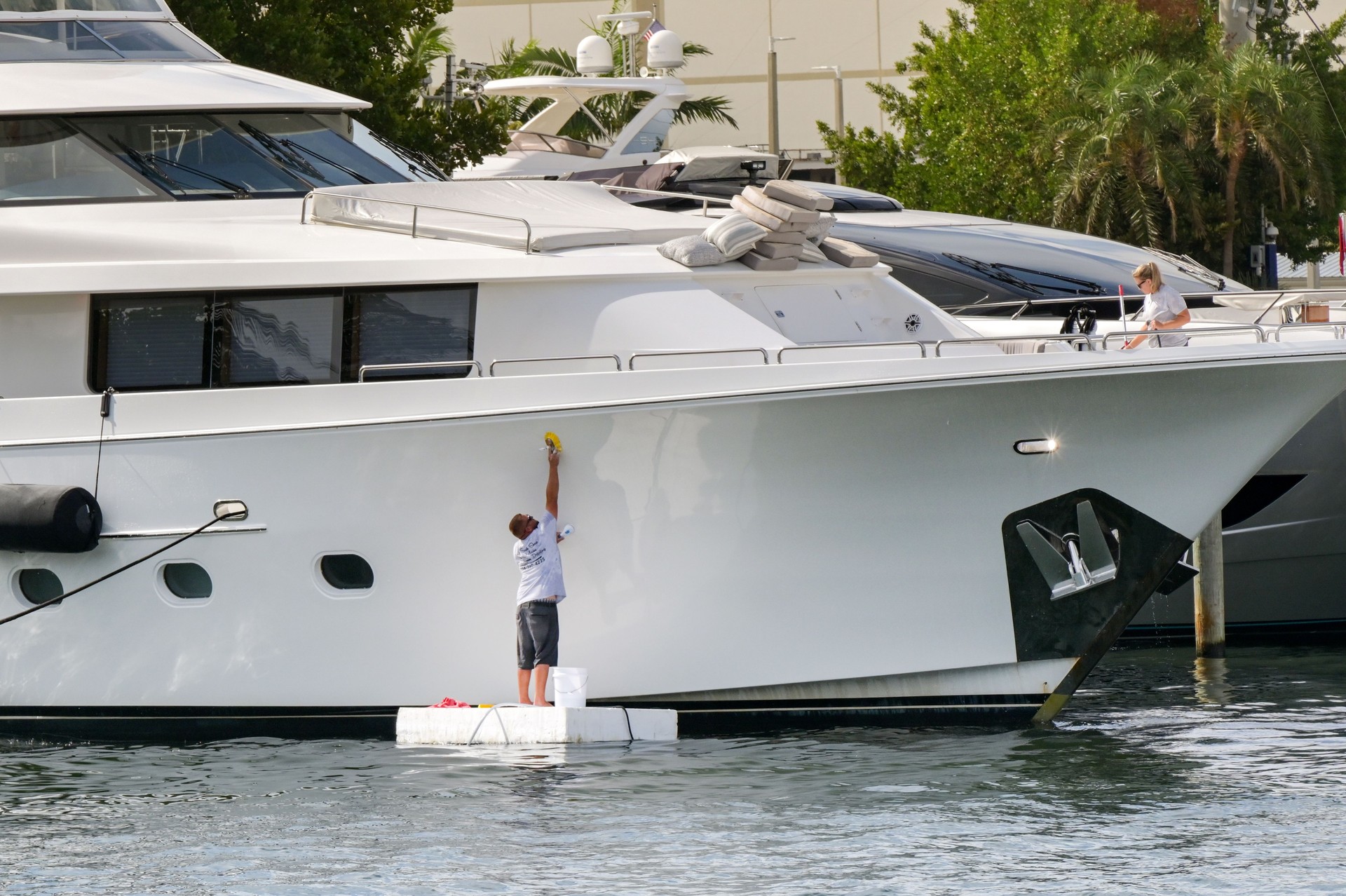 Crew of a luxury yacht cleaning the hull